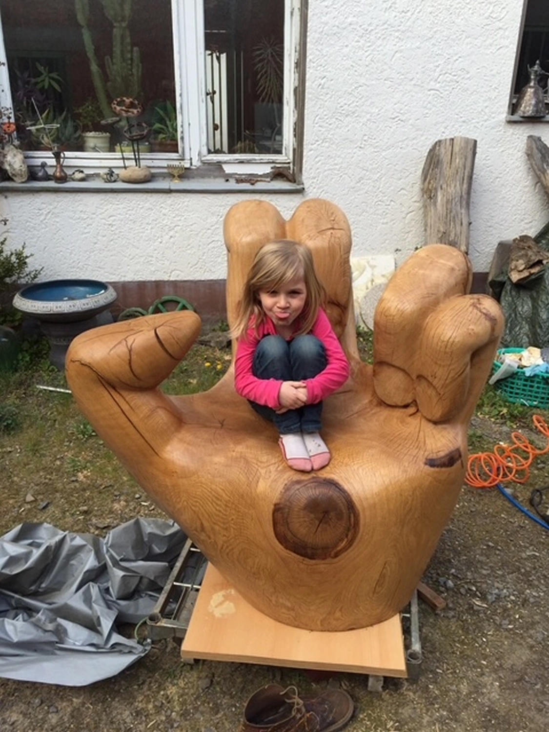 Ein Mädchen sitzt auf einem handgefertigten hölzernen Handstuhl